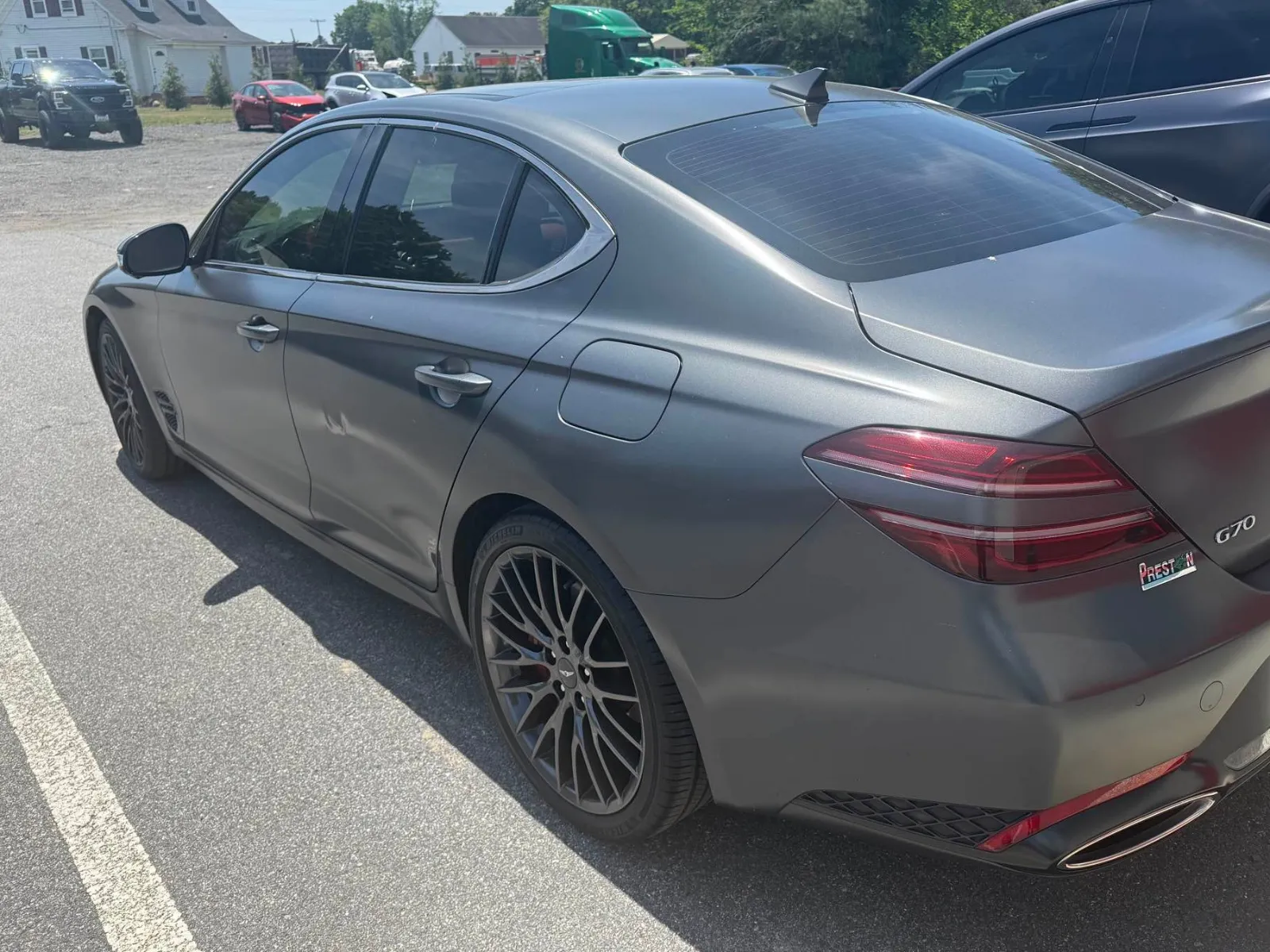 Gray Genesis G70 sedan before repair, with damage to the rear bumper