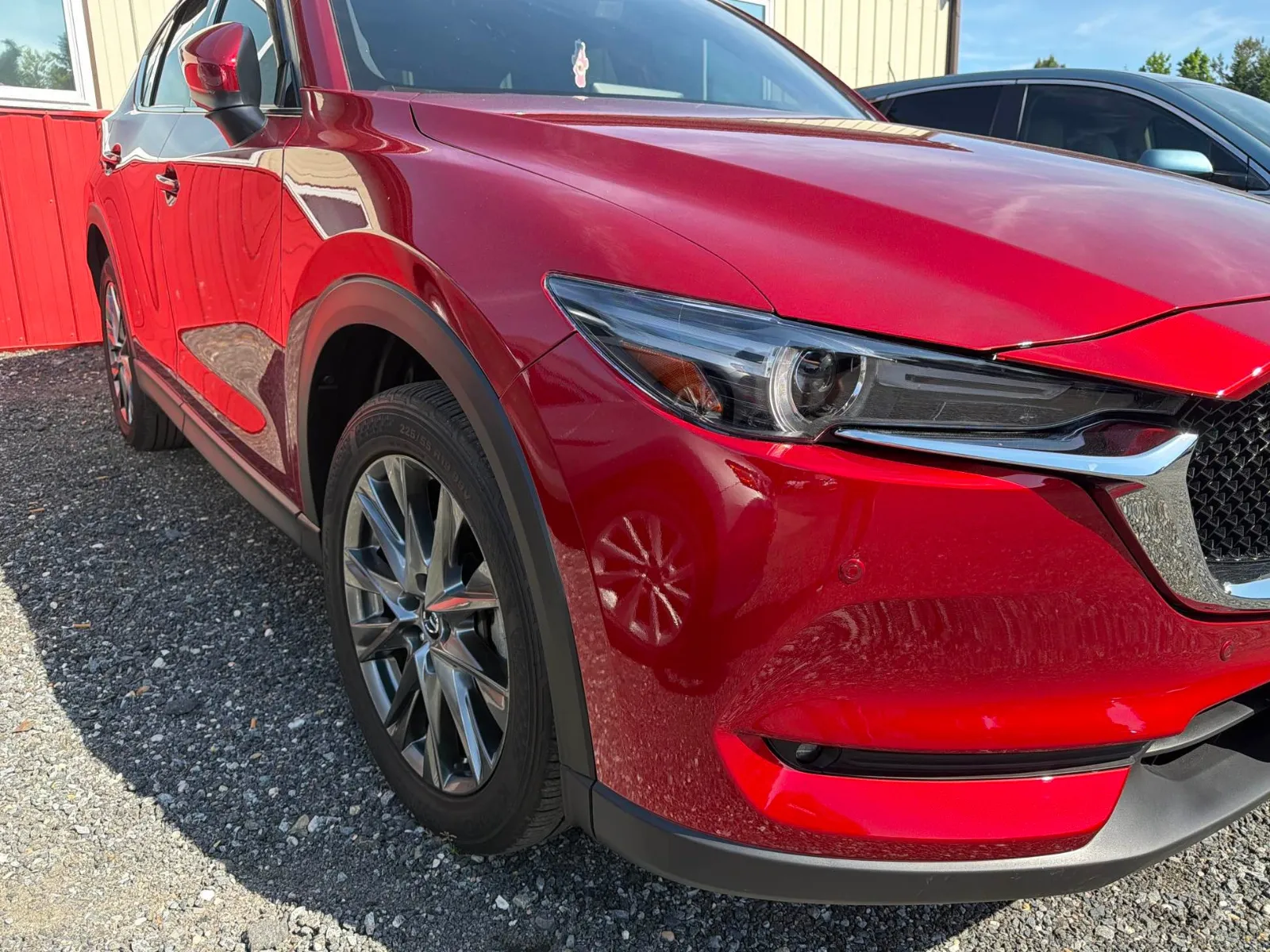 Red Mazda SUV after repair, front bumper and fender restored